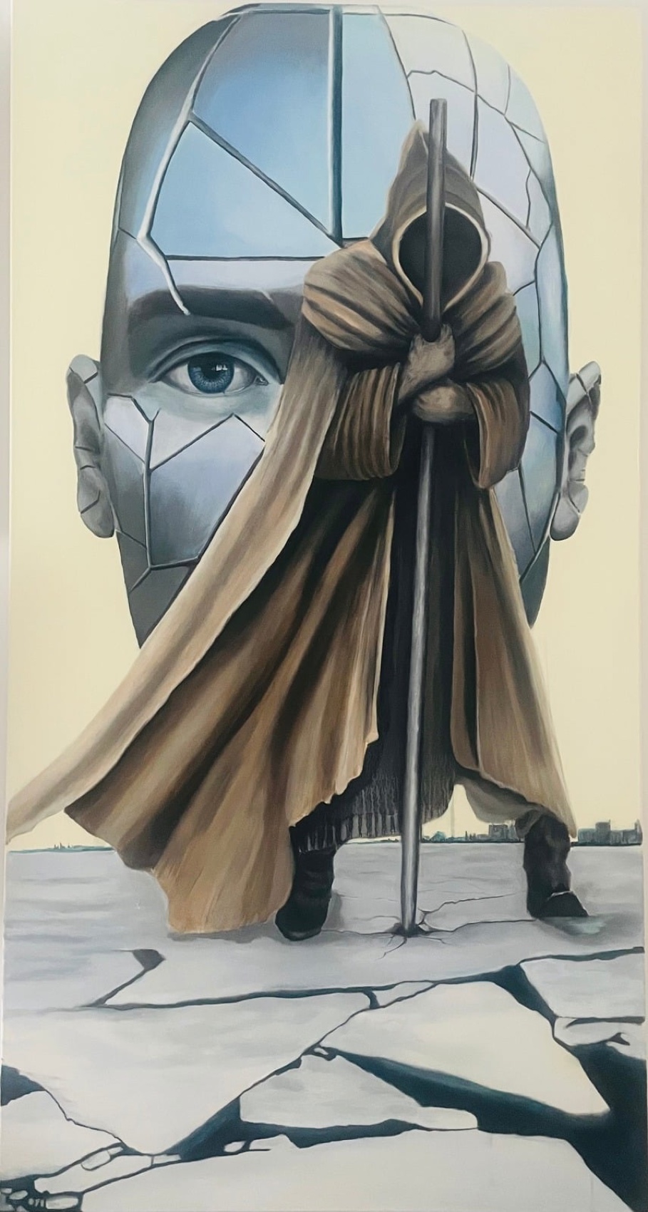 A surreal cracked-mirror head behind a cloaked figure with a staff.